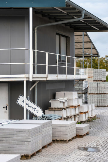 Stacks of concrete pavers outside a building.