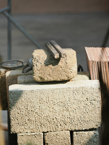 Stack of construction bricks with metal tools on top